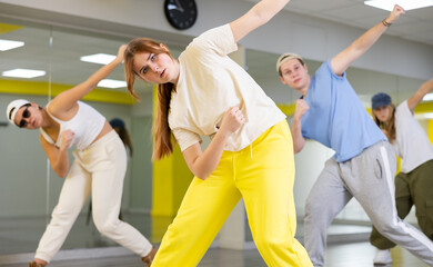 Sports girl teenager rehearsing modern dances in dance hall