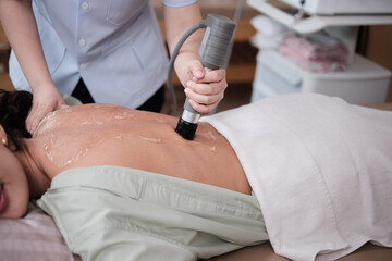 Closeup shot, Hispanic female patient is recovery treated, gel ultrasound for back pain relief by...