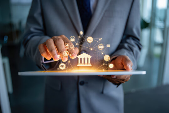 Man in suit holding tablet with glowing bank icon and connected digital network interface overlayed