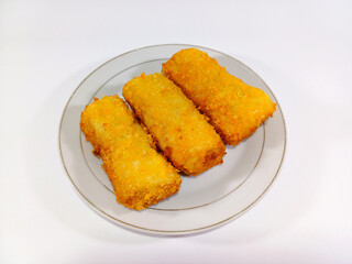 Three golden-brown risoles, neatly arranged on a white plate. Crispy with a textured, breaded coating sits on a white background. Related to Indonesian cuisine, fried snacks, appetizers, party food