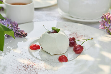 Creamy cherry mousse pastry in bright natural lighting, overhead composition on white plate