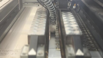 Industrial laser machine welding metal, a robotic mechanism in a factory. Technology concept. A flat sheet of stainless steel is being welded with flashes. Front view. Type C.