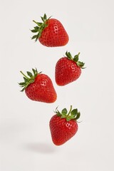 Red strawberries suspended in air – healthy food creativity on clean white background

