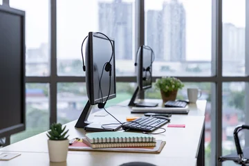 Call center desk with computer monitor, headset, keyboard, and office supplies © wirojsid