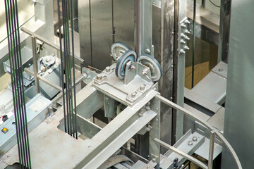 Rollers and cables at the top of the elevator cabin. Suspension of the passenger elevator cabin. © Борис Бондарчук