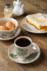 Traditional Malaysian Kopitiam Breakfast Set with Half-Boiled Eggs, Kaya Toast, and Black Coffee on the table