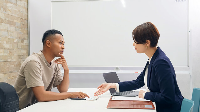 A black man and a Japanese female staff member having an interview