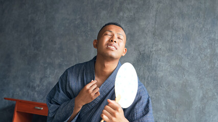 A foreign man wearing a yukata and fanning himself with a fan