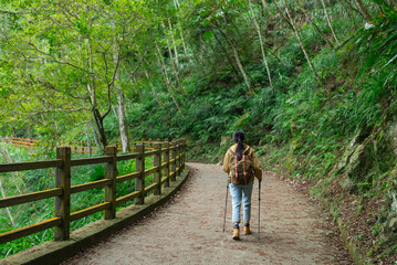 Fototapeta premium Woman Hiking Through Autumn Mountain Landscape