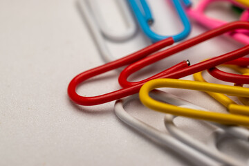 Colored paper clips and white background