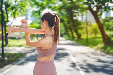 Rear view of asian stretching exercise woman at outdoors public park wellness healthy lifestyle