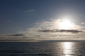 Obraz premium The sky is blue and the sun is shining on the water