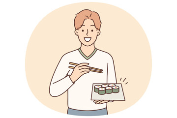 Man holding plate of maki rolls invites to dine in japanese restaurant with delicious healthy food