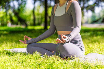 Practicing yoga outdoors on a sunny day in a lush green park for relaxation and mindfulness