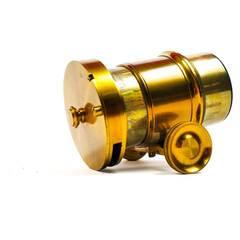 Ancient vintage brass lens for camera with rack and pinion focusing isolated on a white background