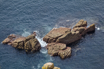 Cowloe, a granite rocky islands in the sea in Sennen Cove. Cornwall. England. UK