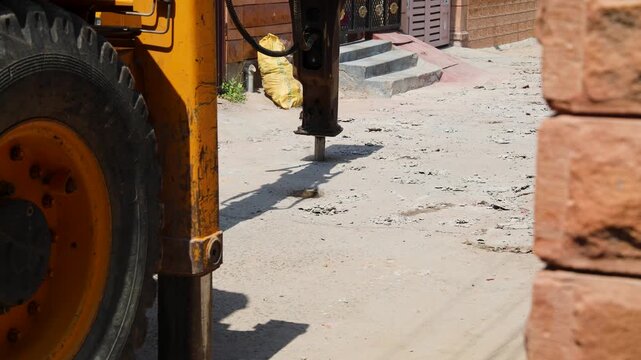heavy machine breaking pavement for daytime construction