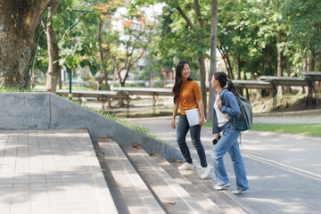 Two university students walking up stairs on campus and talking