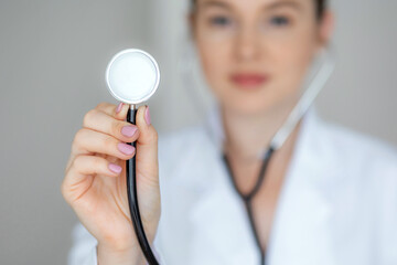 Close-up of stethoscope held by professional healthcare worker in white coat