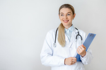 Smiling female doctor holding a clipboard and wearing a stethoscope in casual attire