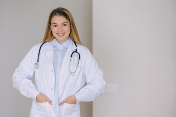 Professional female doctor in white coat smiling in a bright hospital setting