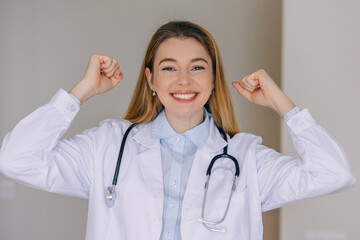 Confident female doctor celebrating success and smiling brightly