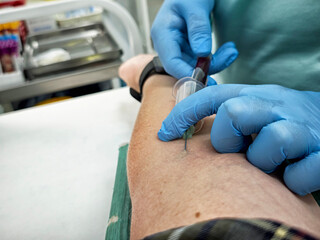 Blood collection process occurring in a medical facility with healthcare professional drawing blood...