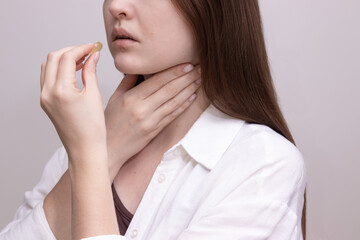 Female experiencing sore throat preparing to take lozenge for sore throat relief.  Concept of cold...