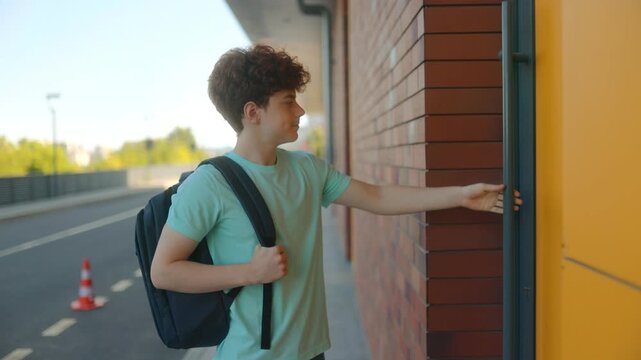 Curly-haired redhead teen boy pulling on a locked school building door