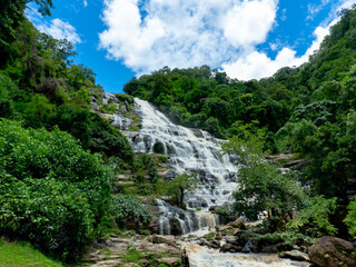 The nature of the waterfall in the forest that flows strongly during the rainy season. Strong current in the river, waters turned muddy after heavy rains in autumn.