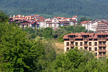 Wooden chalet hotel houses and summer mountains panorama in bulgarian ski resort Bansko, Bulgaria