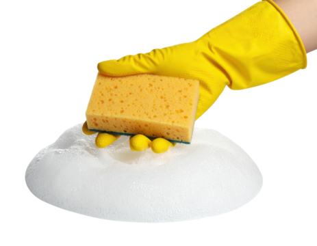 A hand wearing a yellow rubber glove holds a yellow sponge over a pile of white soap suds on a black background.