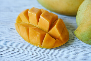 mango fruit on white wooden background, close up, selective focus
