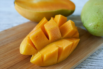 chopped mango on a wooden board on a white background, close-up