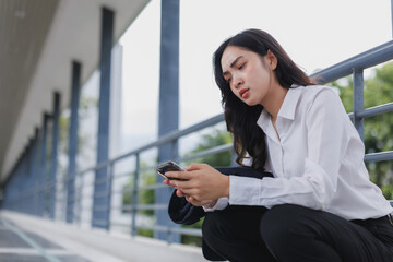 Obraz premium Sad businesswoman reading bad news on smartphone in urban setting