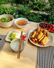 Dining in the garden - vietnamese food: nem rán ( fried spring rolls ), salad, fresh berries and...