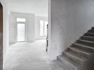 Interior of a new house under construction. Interior of unfinished house: empty room with large...