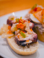 Colorful pintxos with octopus and vegetables on crusty bread in San Sebastian, Spain—capturing the essence of Basque cuisine, perfect for food, travel, and culture themes.