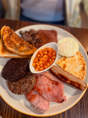 Traditional Scottish breakfast served in Edinburgh, featuring haggis, black pudding, bacon, eggs, sausage, baked beans, and toast. A hearty version of the classic full British breakfast