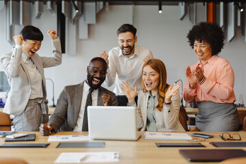 Group of business professionals celebrating successful teamwork in office