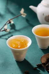 Tea leaves and tea set interior scene, pouring tea from kettle into cup