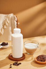 White milk plastic bottle and milk in glass with blank label, warm scene with sunlight indoor background