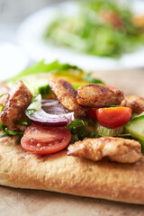 Pita bread with Chicken Breast, Cherry Tomatoes, Cucumber and Rocket. Close up.	