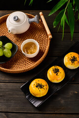 Egg yolk pastry in a Chinese style table setting, dark photography background