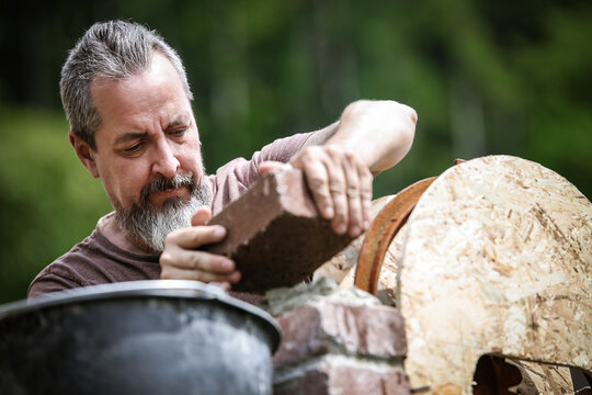a man is building a wall with historic looking bricks