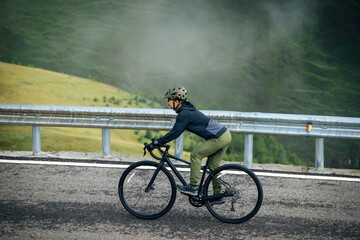 Cyclist riding road bike at the beautiful mountain top road