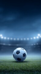 Fototapeta premium Soccer ball on a green field under stadium lights
