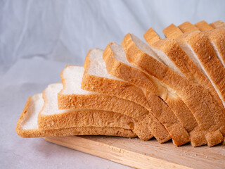 Toasted white bread loaf sliced on white background.