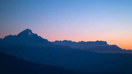 Majestic mountain range during blue hour, with a soft gradient of twilight colors.