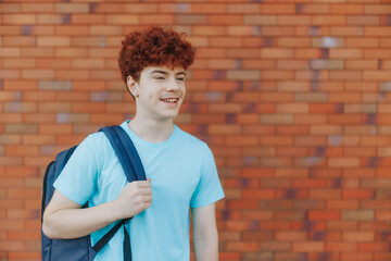 Confident Redhead Teen Boy Standing Calmly Against Brick Wall